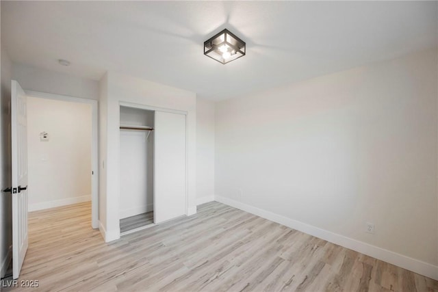 unfurnished bedroom featuring light hardwood / wood-style floors and a closet