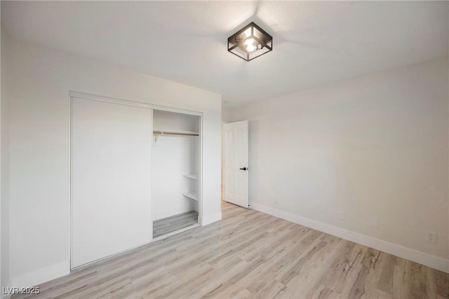 unfurnished bedroom with light hardwood / wood-style floors and a closet