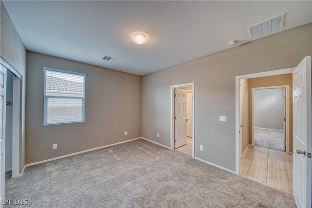 unfurnished bedroom with light carpet and a textured ceiling