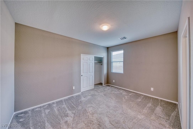 unfurnished bedroom with a closet, carpet flooring, and a textured ceiling