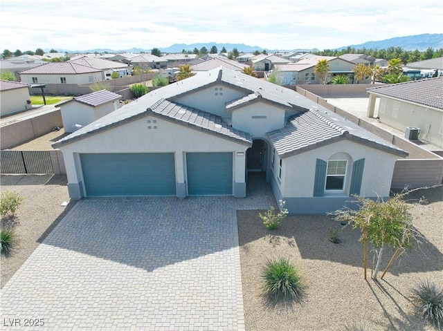 view of front of house with a garage, central AC, and a mountain view