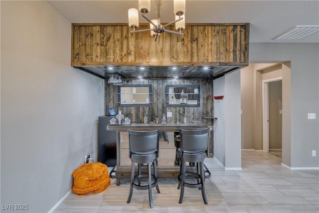 bar with decorative backsplash and a chandelier