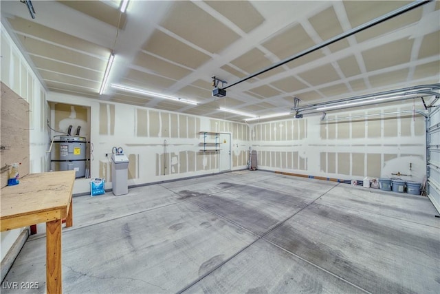 garage featuring strapped water heater and a garage door opener