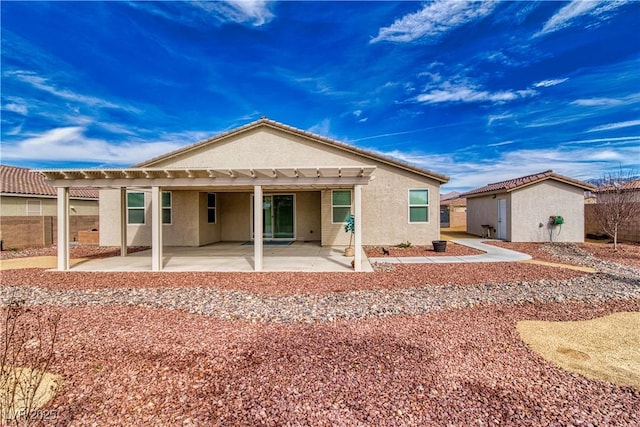 rear view of house with a storage unit and a patio