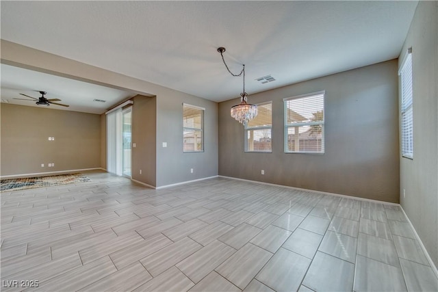 empty room featuring ceiling fan with notable chandelier