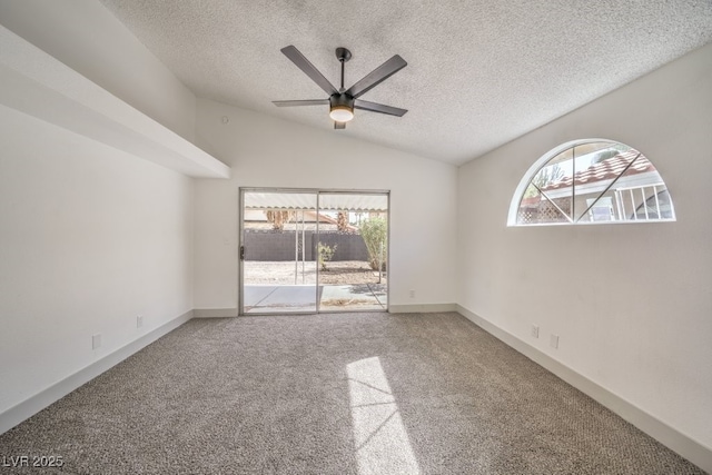 carpeted empty room with ceiling fan, lofted ceiling, and a textured ceiling