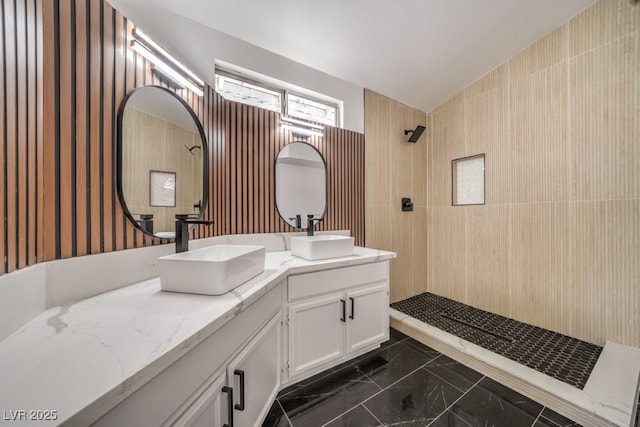 bathroom with tiled shower and vanity