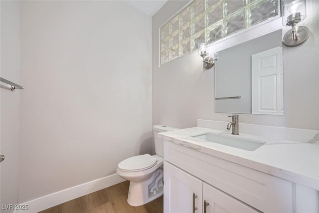 bathroom with hardwood / wood-style flooring, vanity, and toilet