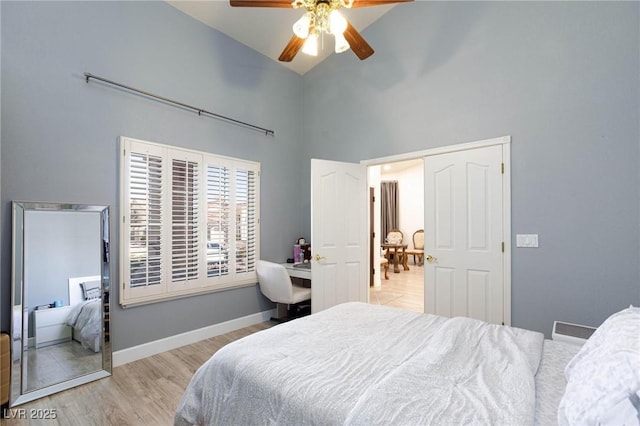 bedroom with light hardwood / wood-style flooring, high vaulted ceiling, and ceiling fan