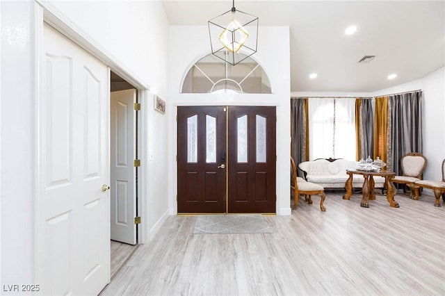 entrance foyer with an inviting chandelier and light wood-type flooring