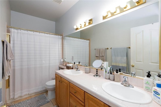 bathroom with tile patterned flooring, vanity, and toilet