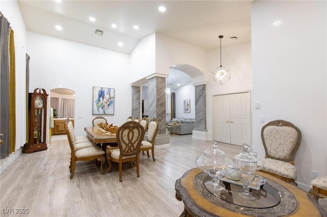 dining area featuring a high ceiling and light wood-type flooring