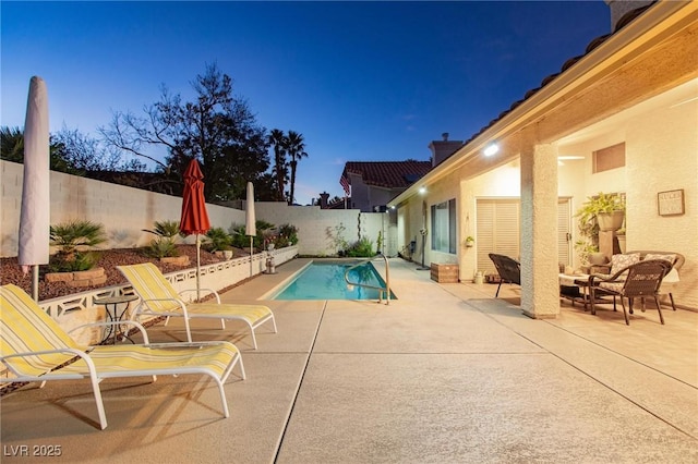 pool at dusk with a patio