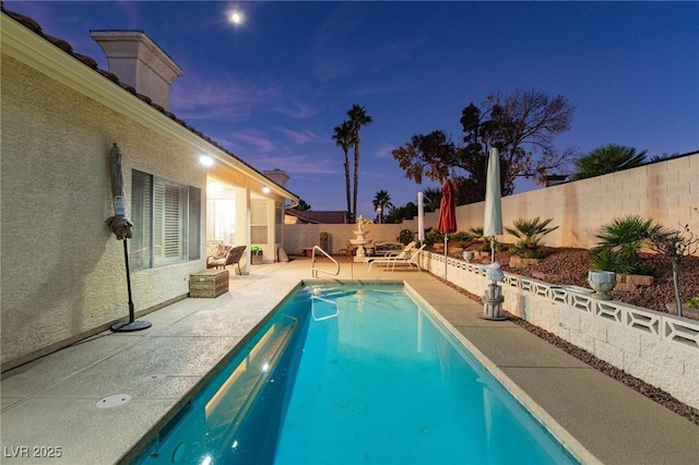 pool at dusk featuring a patio