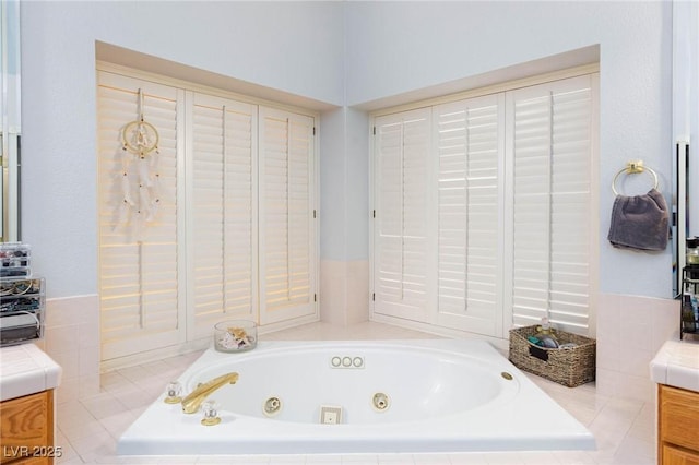 bathroom with vanity and tiled bath