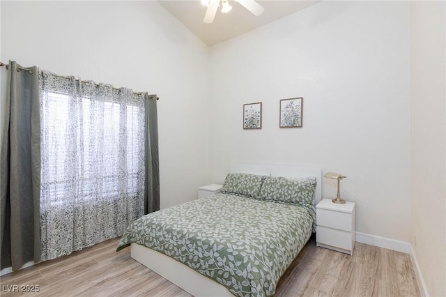 bedroom with ceiling fan, lofted ceiling, and hardwood / wood-style floors