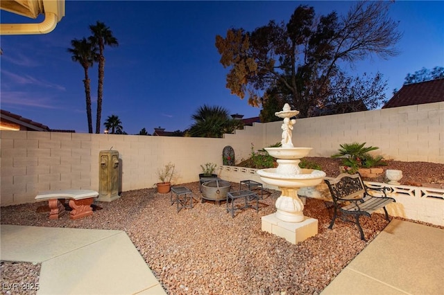 yard at dusk featuring a patio