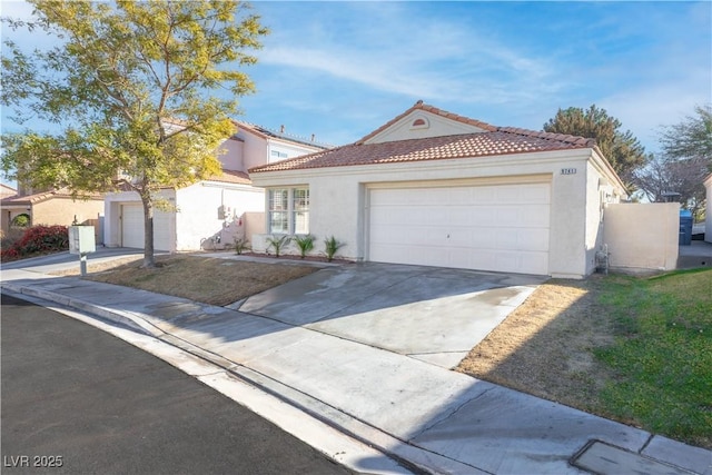 view of front of home featuring a garage, a tiled roof, driveway, and stucco siding