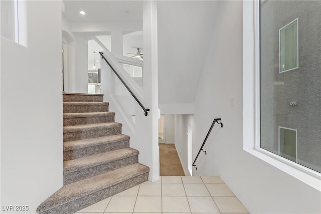 stairs with ceiling fan and tile patterned floors