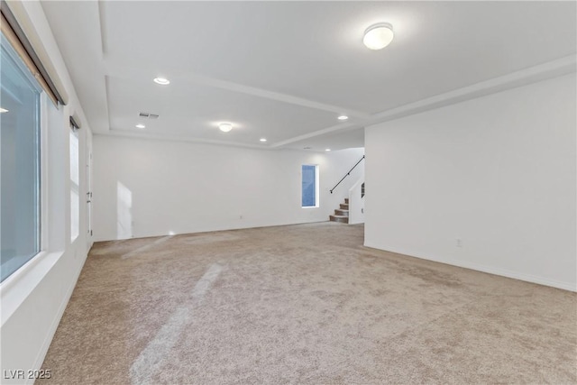 carpeted empty room with a tray ceiling