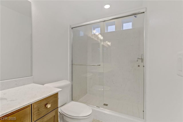 bathroom with vanity, toilet, and a shower with shower door