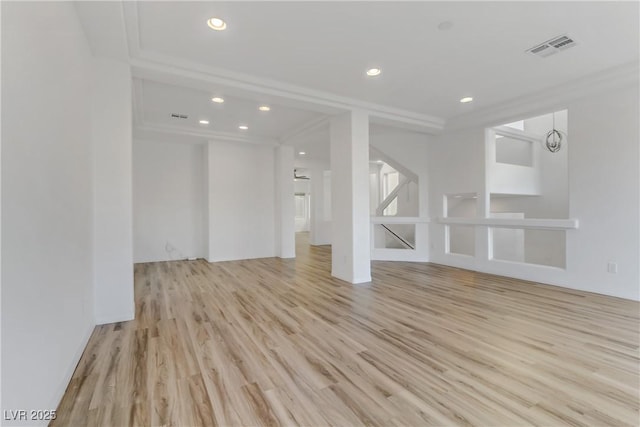 unfurnished living room featuring crown molding and light wood-type flooring