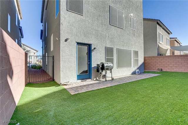 rear view of property with a lawn and a patio