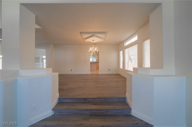 stairway featuring hardwood / wood-style flooring and a chandelier