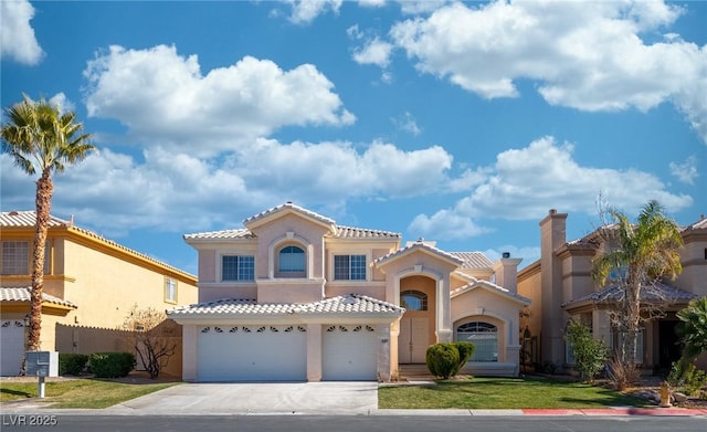 mediterranean / spanish house featuring a garage and a front yard