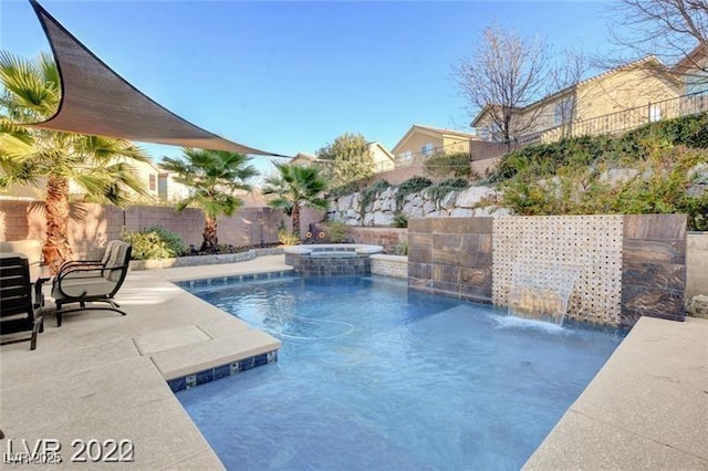 view of pool with a patio area, pool water feature, and an in ground hot tub