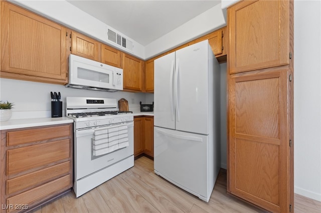 kitchen featuring white appliances and light hardwood / wood-style floors