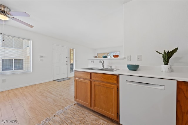 kitchen with dishwasher, sink, ceiling fan, and light hardwood / wood-style flooring