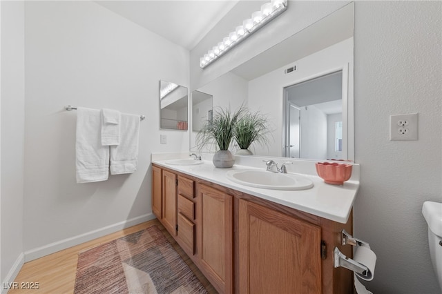 bathroom with vanity, vaulted ceiling, and hardwood / wood-style floors