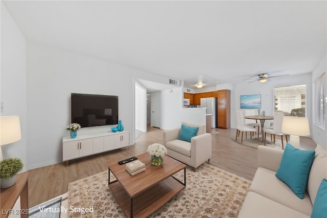 living room featuring ceiling fan and light hardwood / wood-style floors