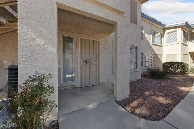 doorway to property with cooling unit and a patio