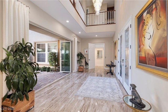 foyer entrance featuring a towering ceiling and french doors