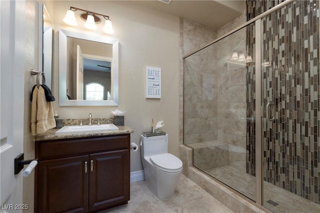 bathroom with tile patterned flooring, vanity, a shower with shower door, and toilet