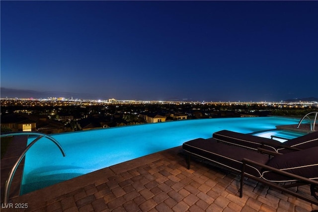 view of pool at twilight