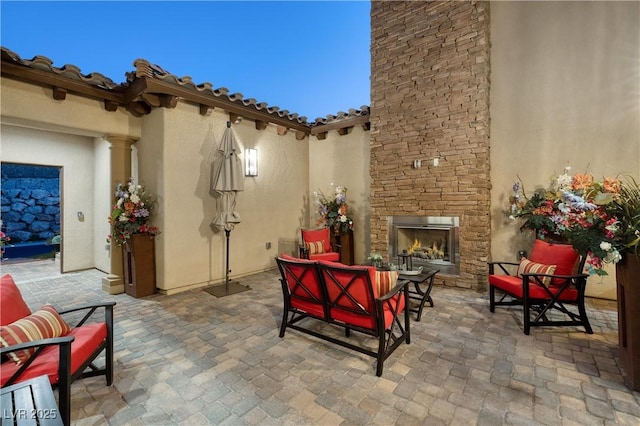 view of patio with an outdoor living space with a fireplace