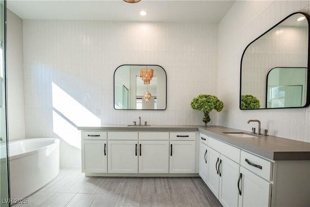 bathroom with vanity, tile walls, and a washtub