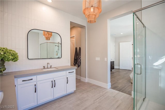 bathroom featuring vanity, wood-type flooring, tile walls, and an enclosed shower