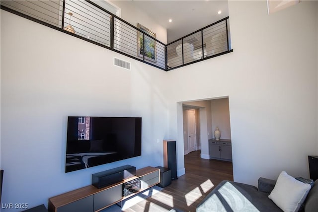 living room featuring dark hardwood / wood-style flooring and a high ceiling