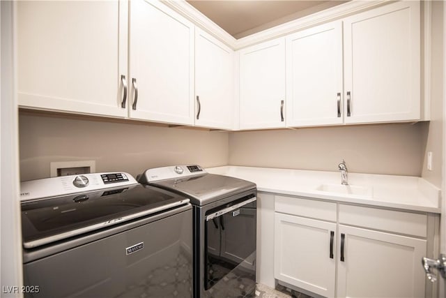 washroom with cabinets, independent washer and dryer, and sink