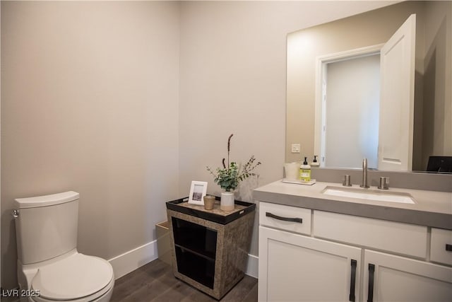 bathroom with vanity, toilet, and hardwood / wood-style floors