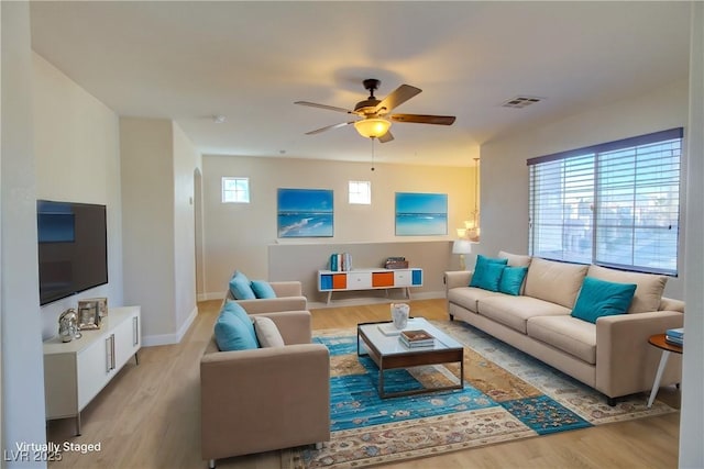 living room with light hardwood / wood-style flooring and ceiling fan