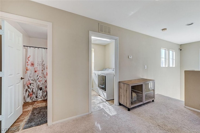 kitchen featuring light colored carpet and washing machine and clothes dryer