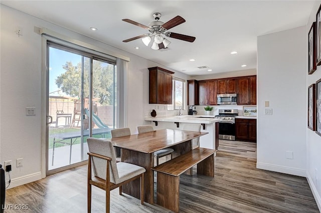 kitchen featuring hardwood / wood-style floors, ceiling fan, and appliances with stainless steel finishes