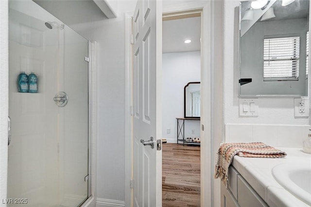 bathroom featuring hardwood / wood-style flooring, vanity, and walk in shower