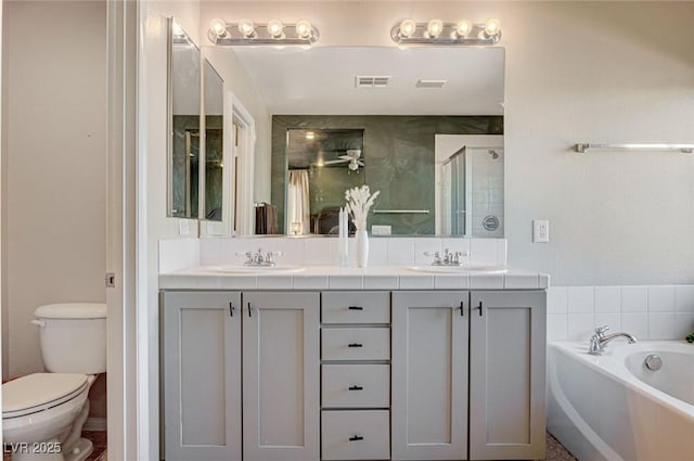 full bathroom featuring vanity, toilet, and independent shower and bath