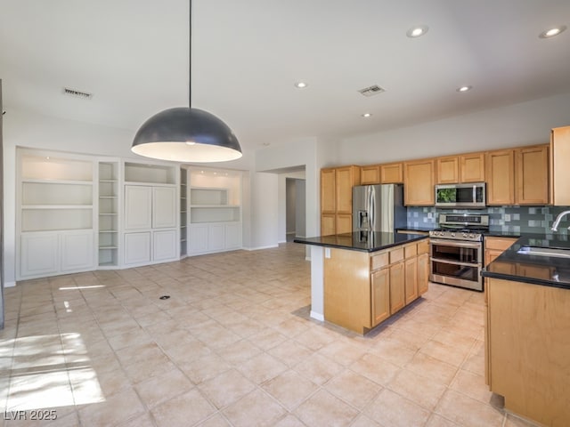 kitchen with sink, tasteful backsplash, a center island, appliances with stainless steel finishes, and pendant lighting